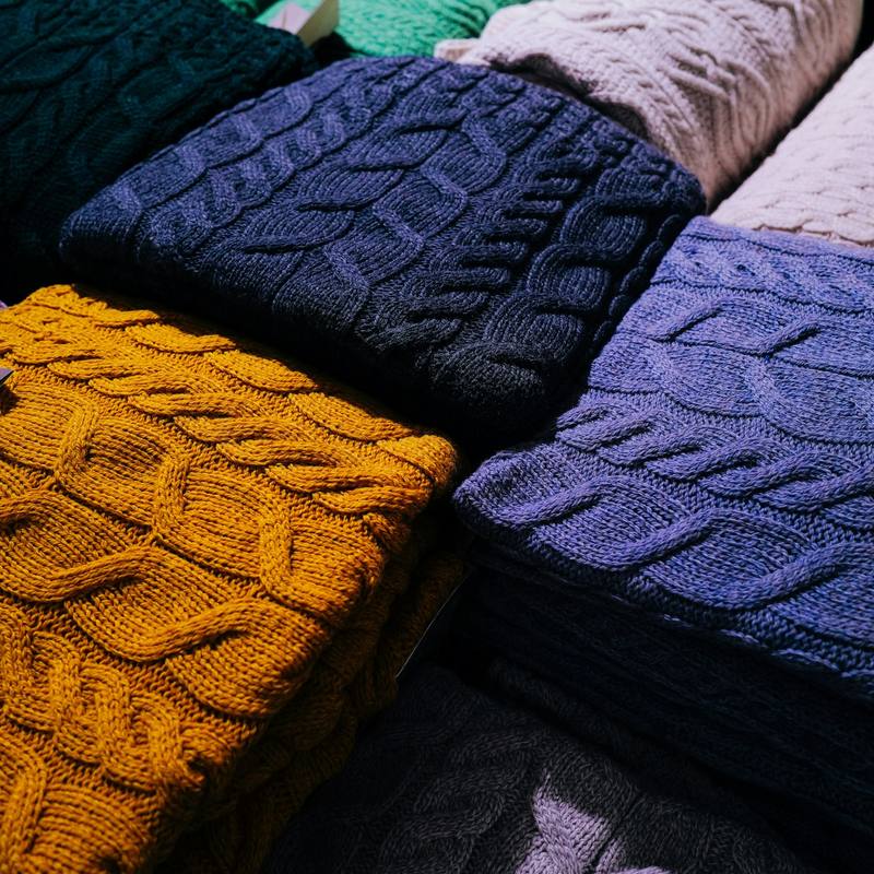 Stacks of colourful cable-knit jumpers